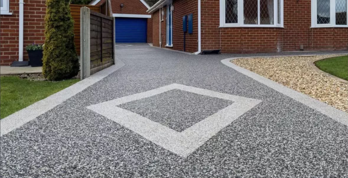 Grey resin bound driveway with a contrasting diamond feature and white border