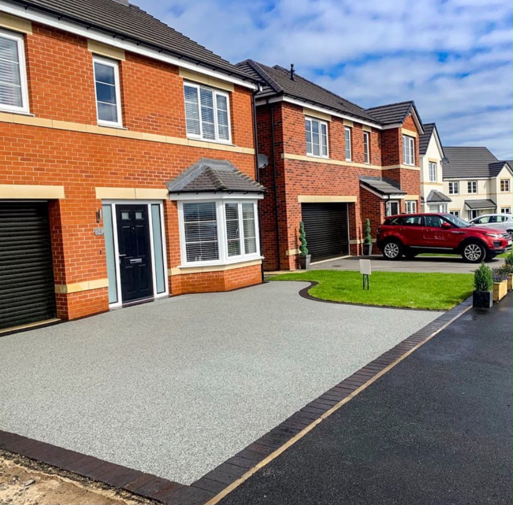 Newly laid silver resin bound driveway with tegula block paving border