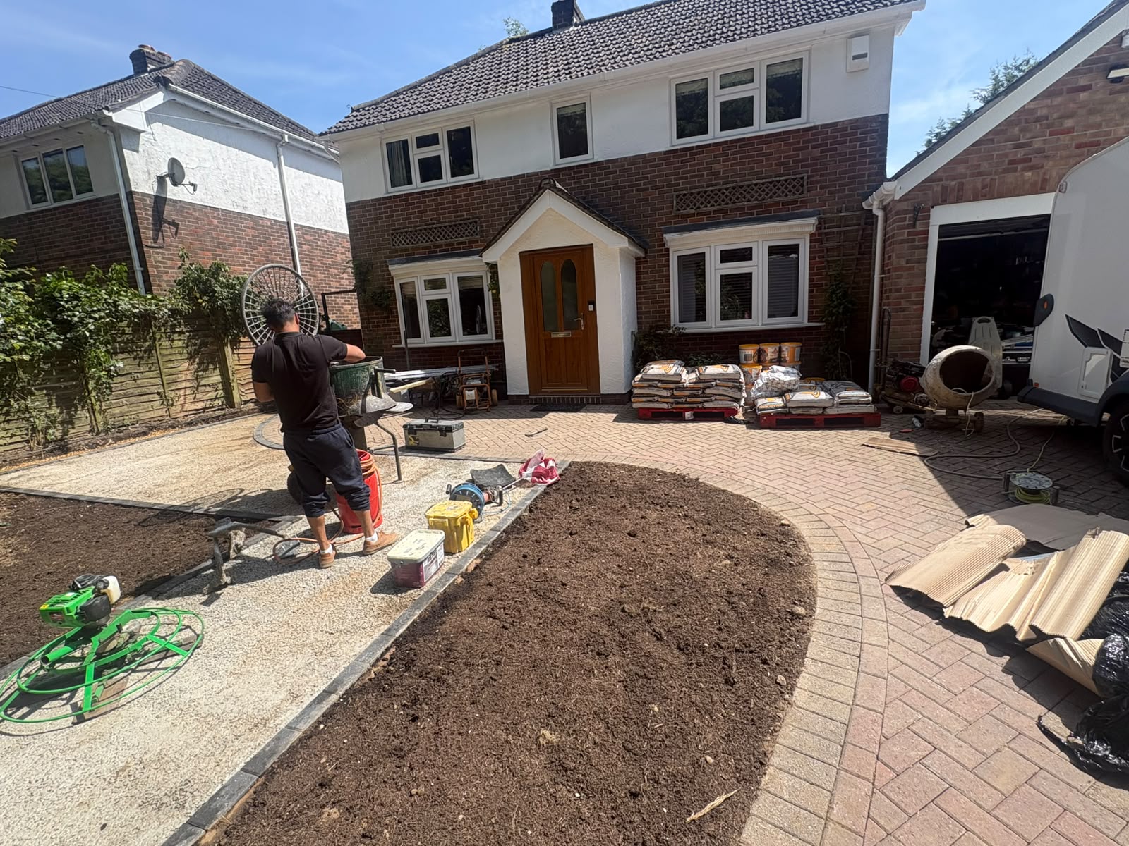 Block paving driveway in progress with prepared bed and materials on site