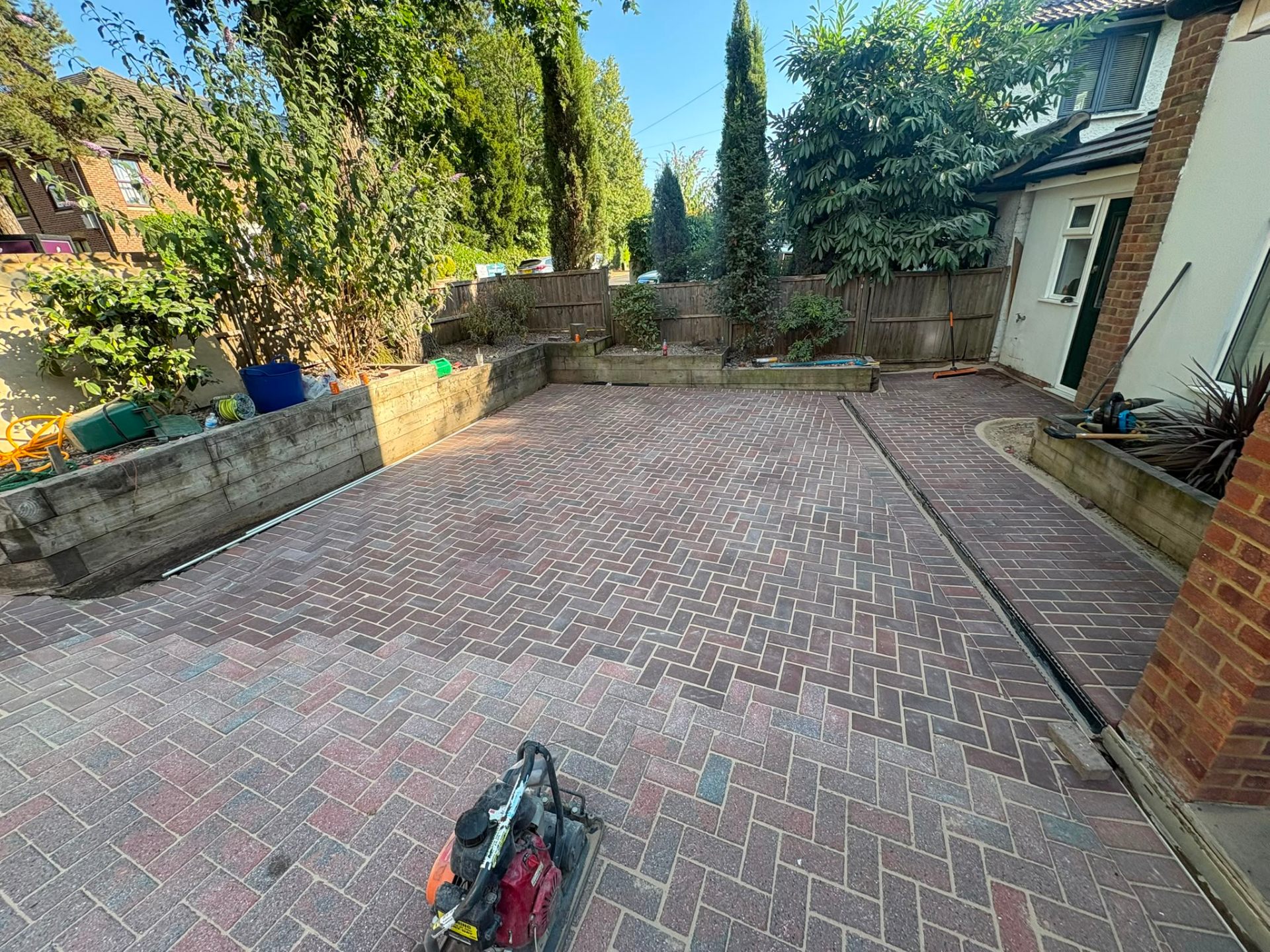 Fresh red block paved driveway with three parking bays and grey border