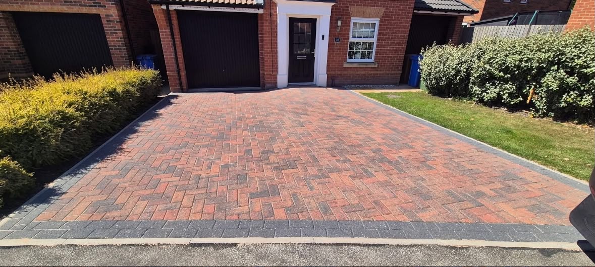 Charcoal block paving driveway with contrasting brick border kerb