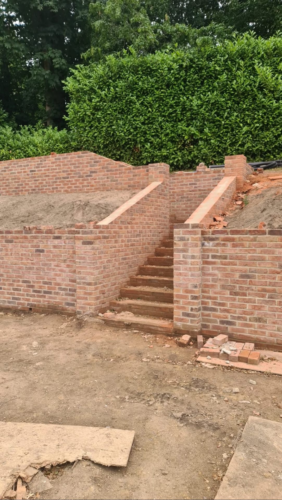Retaining brick garden walls with integrated brick steps and rowlock course