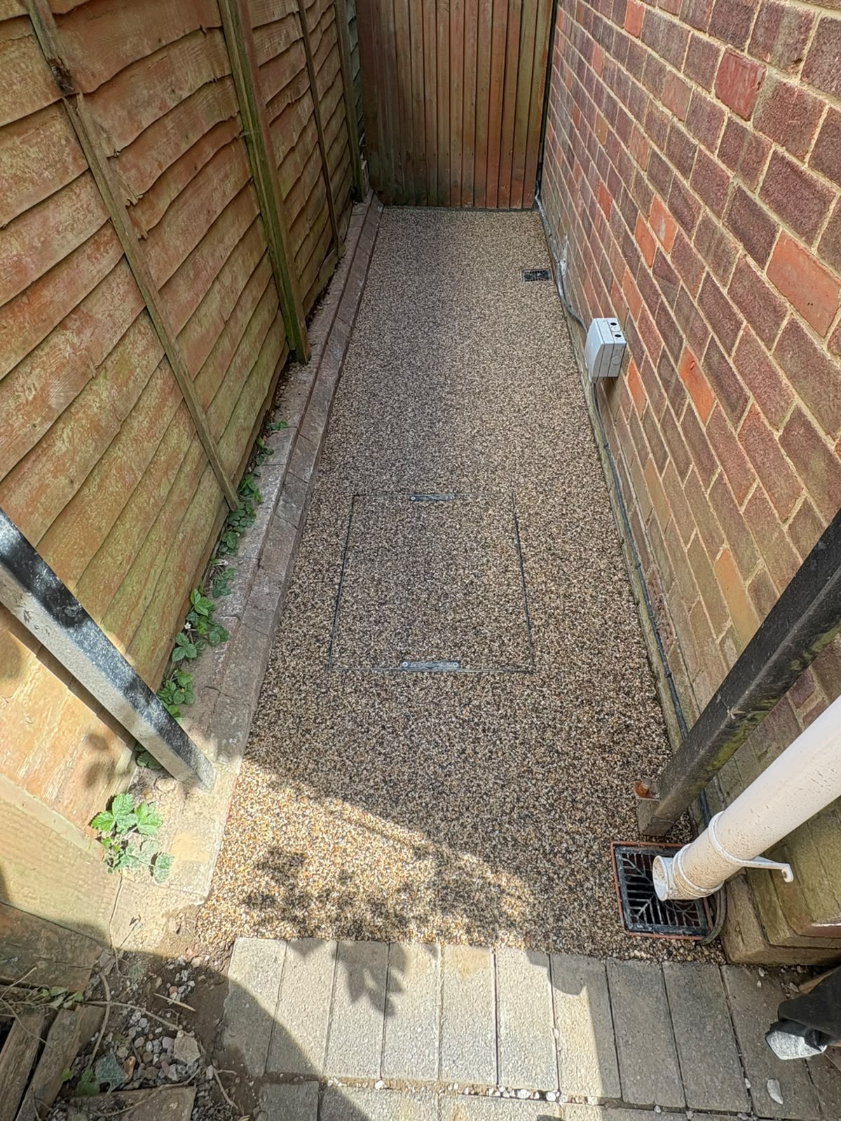 Small resin bound side alley with recessed manhole cover and drainage