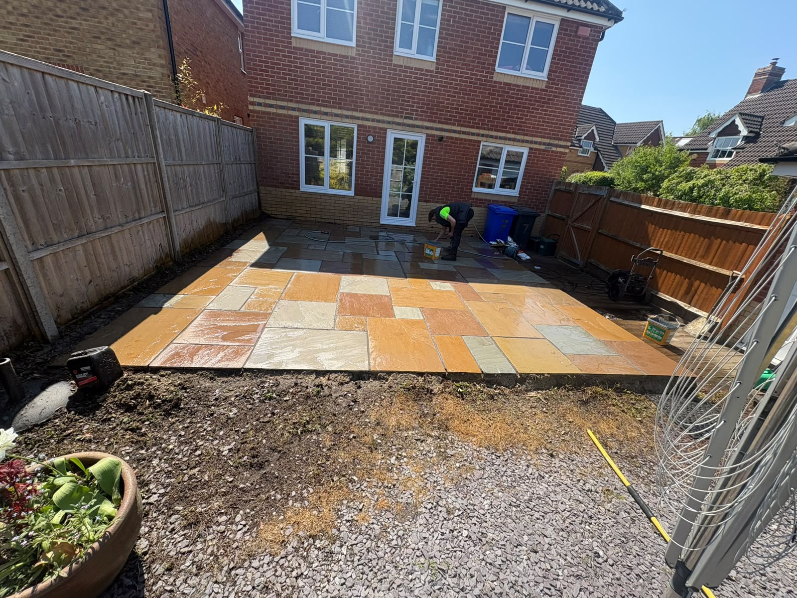 Rippon buff Indian sandstone patio being installed at the rear of a house