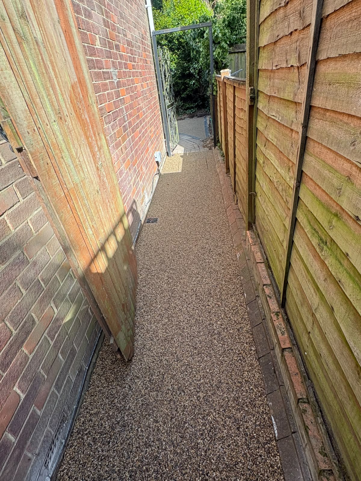 Resin bound pathway running down the side of a red brick property