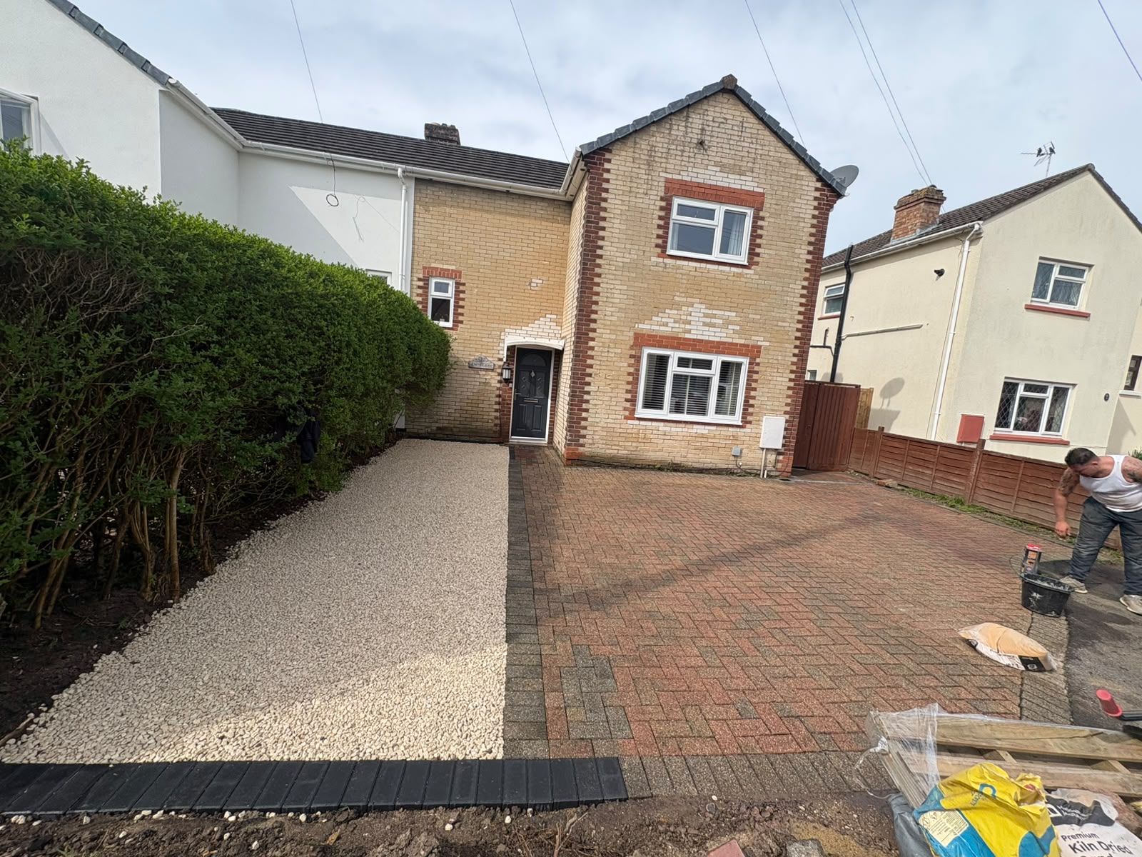 Half-completed resin driveway installation next to existing block paving